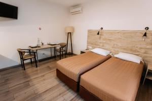 文尼察的住宿－Smart Apart，酒店客房设有两张床、一张桌子和一张桌子。