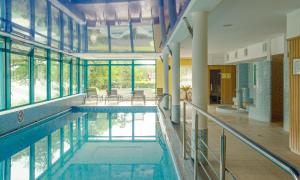 una piscina en un edificio con ventanas y una piscina en SPA Barlinek, Hotel Alma & SPA - UWAGA - styczen do marzec 2026 basen nieczynny!, en Barlinek