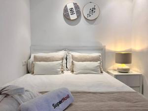 um quarto com uma grande cama branca com almofadas em La Colombe de Sidi Bou Saïd em Dar Salah Bey