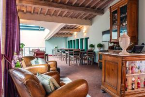 sala de estar con sillas de cuero y mesa en Le Ragnaie, en Montalcino