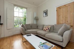 - un salon avec un canapé et une table basse dans l'établissement Chic 2 bedroom House wGarden - De Beauvoir Hackney!, à Londres