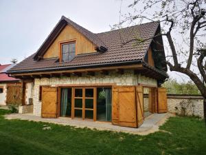 uma casa com portas de madeira e um telhado em Siedlisko Chatka Zagajdzie 