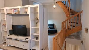 a living room with a tv and a staircase at small Stable - charmantes Häuschen Mitten in Lemgo in Lemgo
