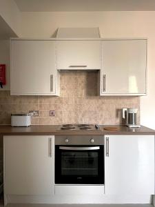 een keuken met witte kasten en een kookplaat oven bij Central 2-bedroom apartment, Montrose in Montrose