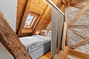 a small bedroom in a log cabin with a bed at A&Y Oldtown Penthouse Loft Luzern in Lucerne