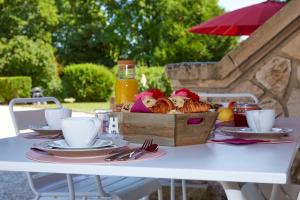 a table with a basket of bread and fruit on it at La Bertonnerie en Champagne in Prunay