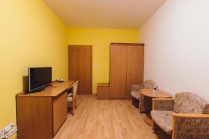 a living room with a tv and a desk with a couch at Hotel Annahof in Domašov