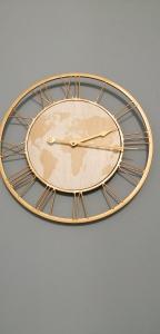 a gold and black clock on a white background at Bloom Apartment in Pero