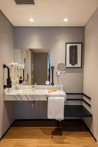 La salle de bains est pourvue d'un lavabo et d'un grand miroir. dans l'établissement Intercity Tatuapé, à São Paulo