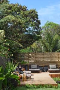 a patio with couches and tables and a fence at Pousada Maria Bonita Noronha in Fernando de Noronha