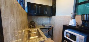 a kitchen with a sink and a blender on a counter at Cozy Nest Oasis - Serviced Apartment in Kigali