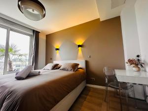 a bedroom with a bed with a desk and a window at Luxury Flat With Terrace & Eiffel Tower View in Paris