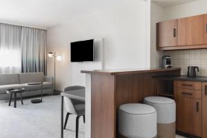 a hotel room with a kitchen and a living room at Courtyard by Marriott Basel in Pratteln