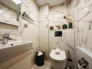 a white bathroom with a toilet and a sink at Luxury Flat With Terrace & Eiffel Tower View in Paris +22 photos