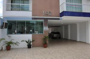 a building with a car parked in a parking lot at Pousada Aliança in Salvador