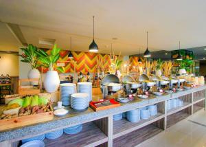 un buffet con platos blancos, ollas y sartenes en Hotel FortunaGrande Seturan Yogyakarta, en Yogyakarta