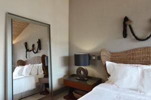 um quarto com um espelho ao lado de uma cama e um bedsenalsenalsenalsenal em Pousada Maria Bonita Noronha em Fernando de Noronha