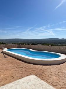 een groot zwembad in een bakstenen tuin bij DJM Palms B&B - No es una casa privada in Ayora