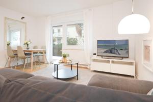 sala de estar con sofá, TV y mesa en Haus "Kehrwieder" Kap Arkona, en Grömitz