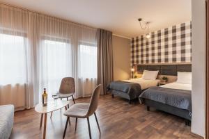 um quarto de hotel com duas camas e uma mesa em Złote Góry em Sienna