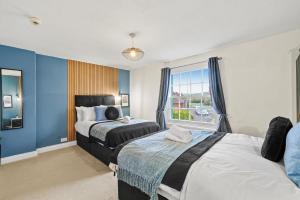 een slaapkamer met 2 bedden en een raam bij The Bristol Harbourside Apartments - Sleeps 16 in Bristol