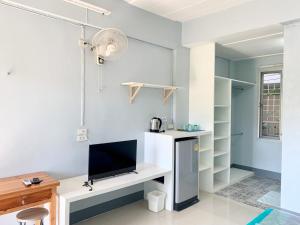 een woonkamer met een tv en een bureau bij PJ PLACE in Chiang Rai