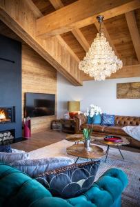 a living room with a couch and a chandelier at Chalet Carte Blanche Cullinan in Val Thorens