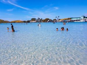 a group of people in the water on a beach at Apartamento único e aconchegante! in Cabo Frio