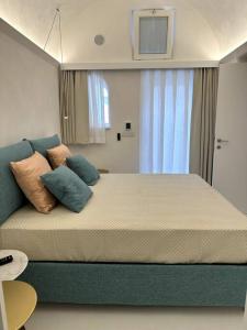 um quarto com uma cama grande com almofadas em Piazzetta Suite, Capri em Capri
