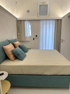 une chambre avec un grand lit avec des oreillers dessus dans l'établissement Piazzetta Suite, Capri, à Capri