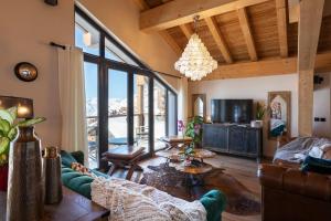 a living room with a couch and a table at Chalet Carte Blanche Orlov in Val Thorens