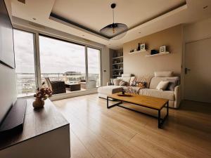 a living room with a couch and a table at Luxury Flat With Terrace & Eiffel Tower View in Paris