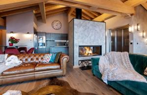 sala de estar con sofá y chimenea en Chalet Carte Blanche Orlov en Val Thorens