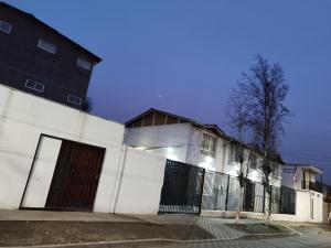 un edificio blanco con una puerta y una valla en Shalom_MatSofy, en Santiago
