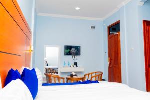 ein Schlafzimmer mit einem Bett mit blauen Kissen in der Unterkunft La Stanar Hotel in Dodoma