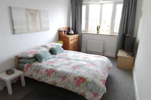 Dormitorio pequeño con cama y TV en Guest suite 50m from the beach, en Bognor Regis