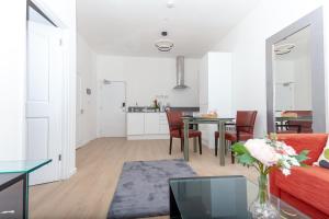 een woonkamer met een rode bank en een tafel bij One Bedroom apartment Serviced apartment Smethwick flat 313 in Birmingham