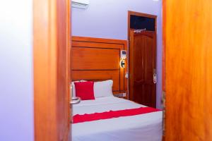 a bedroom with a bed with a red and white blanket at La Stanar Hotel in Dodoma