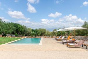 einen Pool mit Stühlen und Sonnenschirmen neben in der Unterkunft Cal Tio 2 Agroturismo YourHouse in Costitx