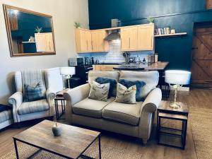 a living room with a couch and two chairs at Old Orchard Cottage, Wykeham in Scarborough