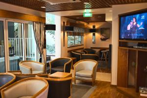 a bar with chairs and a flat screen tv at Hotel Varandas do Atlântico by RIDAN Hotels in Praia da Vitória