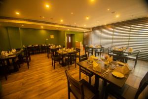 un restaurante con mesas y sillas en una habitación en Hotel Harisree Kollam, en Kollam