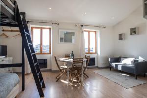 een woonkamer met een tafel en een hoogslaper bij L'Isle en Blanc - Appartement hypercentre - 4 couchages in LʼIsle-sur-la-Sorgue