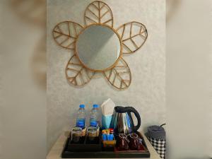 a mirror on a wall next to a counter with water bottles at Mukrada House Boutique Hometel Krabi in Klong Muang Beach