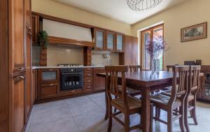 cocina con mesa de madera y armarios de madera en Italian Experience - Sunrise Hill Holiday Home, en Urbisaglia