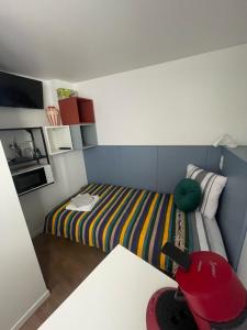 THEIA Hotel & Suites - Limoges Centre في ليموج: غرفة صغيرة بها سرير وطاولة