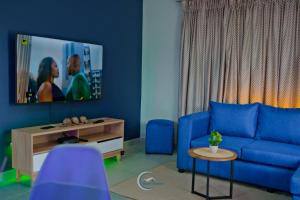 sala de estar con sofá azul y TV en Rinkase residence, en Pretoria