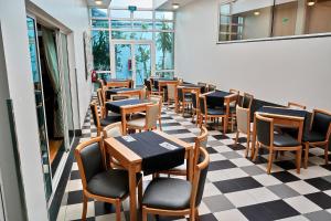 a restaurant with tables and chairs on a checkered floor at Hotel Varandas do Atlântico by RIDAN Hotels in Praia da Vitória