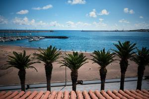 a group of palm trees on a beach with a marina at Hotel Varandas do Atlântico by RIDAN Hotels in Praia da Vitória