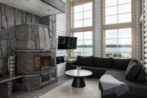 ein Wohnzimmer mit Couch und Kamin in der Unterkunft Lehmonkärki Resort in Asikkala
